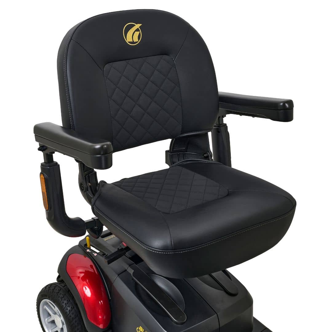 The Buzzaround LX 4-Wheel scooter has a seat with black quilted leather, armrests, a red back panel, two visible wheels, and a gold emblem on the backrest.