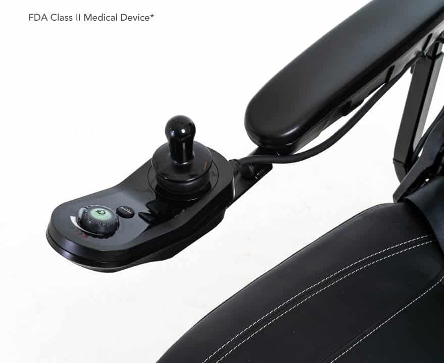 Close-up of a sleek black Jazzy® EVO 614HD Power Chair armrest featuring a joystick control panel with dial and buttons, visible seat stitching. The text states FDA Class II Medical Device*.