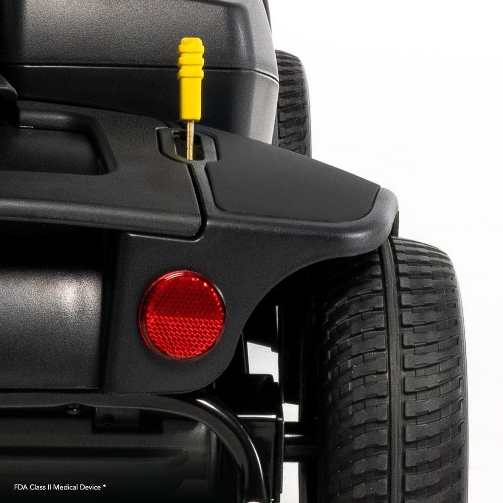 Close-up of a GoGo Elite Traveller 2 mobility scooters rear section with a thick tire, red reflector, and yellow lever. The text FDA Class II Medical Device at the bottom highlights the precision engineering by Pride.