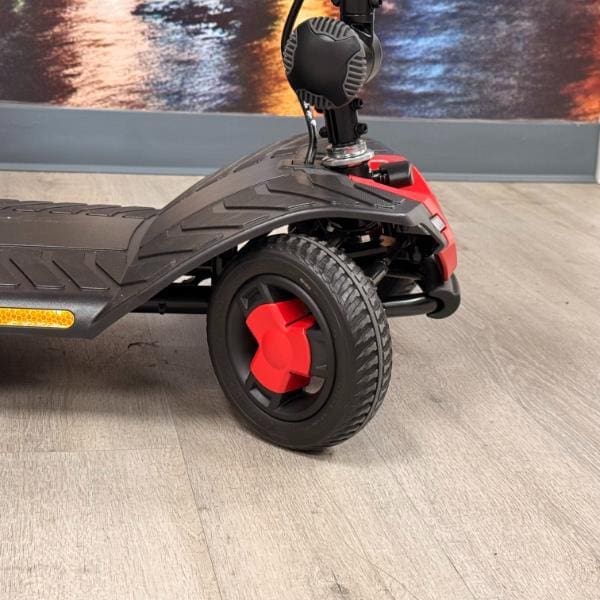 Close-up of the front wheel and foot deck of a Pride Go Go Elite Traveller Gen 3 4-Wheel Scooter.
